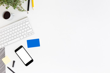 Credit card, smartphone, keyboard and coffee on office desk.