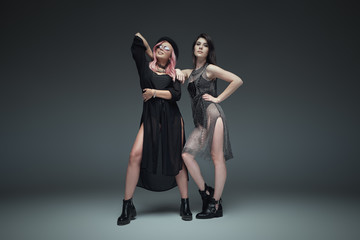 Fototapeta na wymiar Two fashionable girls wearing black trendy outfits posing