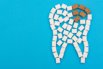 Sugar cubes are laid out in the form of a tooth, and brown sugar symbolizes caries. Sugar destroys tooth enamel and leads to tooth decay.