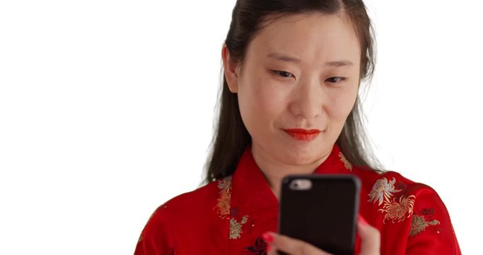 Close up of happy millennial woman smiling for selfie and wearing traditional Chinese fashion on white background, Young smiling Asian woman using smartphone to take selfie for copyspace, 4k