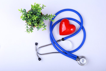 Stethoscope and red heart on white table with space for text. © v_l