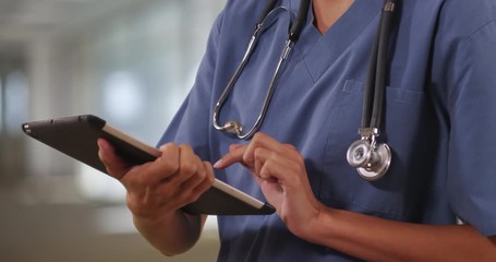 Close up of woman nurse or doctor working on table computer inside hospital, Female medical professional using digital technology, 4k - Powered by Adobe