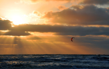 Kitesurfing against the sunset on the North sea