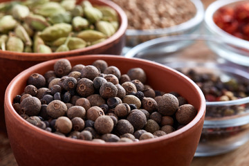 Bowls with different types of spicy on wooden table, top view, close-up, selective focus.