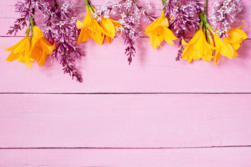 Pink wooden background with bright flowers