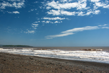 Blue Sky Covering Beach with Rolling Waves