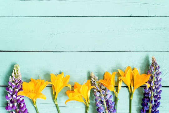 Fototapeta Blue wooden background with various bright flowers