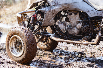 Close-up of dirty atv suspension and angine