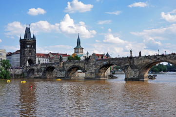 Fototapeta na wymiar View from the surface of the Vltava River to the historical Gothic Charles Bridge - Prague, Czech Republic. UNESCO monument.