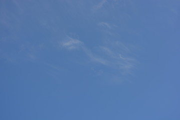 Against the background of a beautiful blue with white translucent tender milk clouds and sunlight