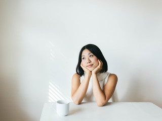 Portrait of young woman looking out the window deep in thought