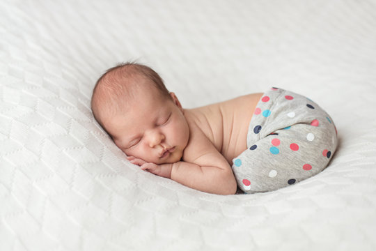 Portrait Of A Newborn Baby Sleeping On Her Tummy