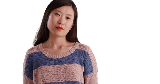 Serious young woman in static pose looking at camera isolated on copyspace, Close-up portrait of Asian millennial female with confident look in front white background, 4k