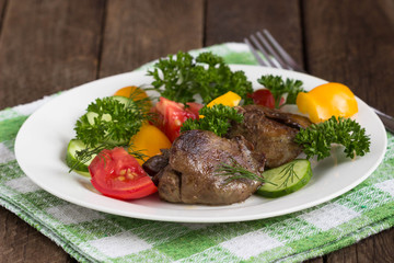 Warm salad with chicken liver, sweet peppers, cherry tomatoes and parsley.. shallow DOF