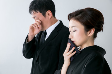 お葬式で泣く男女
