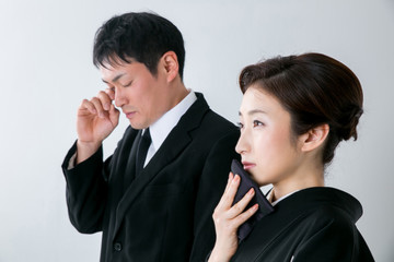 お葬式で泣く男女
