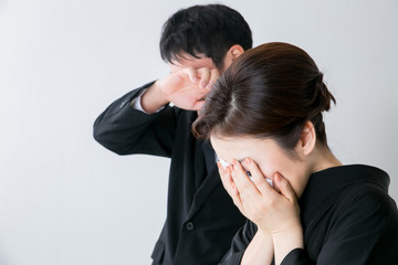 お葬式で泣く男女
