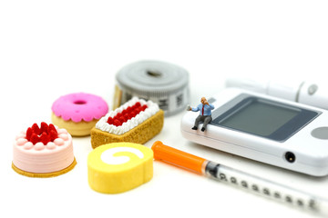 Miniature people : Doctor and patient with Glucose meter diabetes test and Syringe with measuring tape,concept of diabetes, healthy lifestyles and nutrition