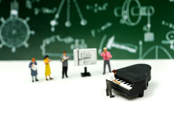 Miniature people : Teacher and student with piano class of music.