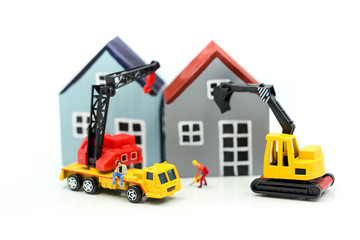 Miniature people : businessman Construction site with equipment. Crane builds a house,House in construction concept.