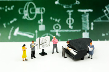 Miniature people : Teacher and student with piano class of music.