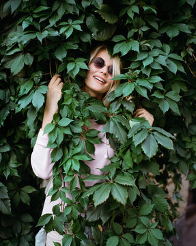 Charming girl posing in green bush