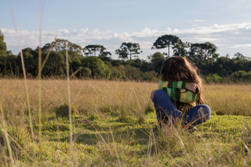 Criança triste no campo 