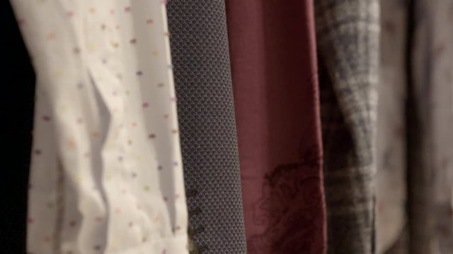 Male clothes, jackets and colorful shirts hanging on clothes rail.