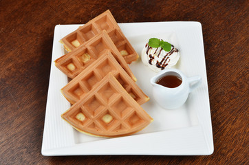 Fresh and delicious waffle with cream and  syrup on plate 
