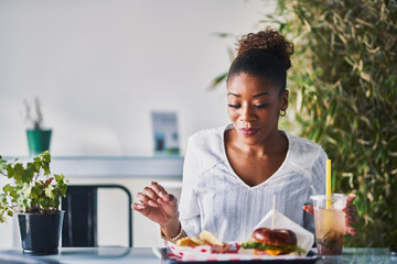 african american woman sitting down to enjoy healthy vegan fast food - obrazy, fototapety, plakaty