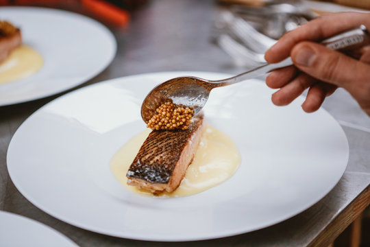 Adding sesame caviar on top of cooked Salmon