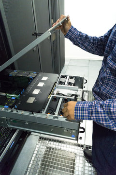 Technician opening the top of a server in a server room