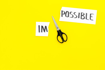 Belief in yourself concept. Cutting the part im of written word impossible by sciccors. Yellow background top view copy space