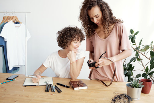 Cheerful colleagues looking at photos
