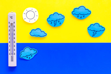 Weather forecast concept. Air temperature. Termometer among cloud and lightening, sun, rainy clouds...