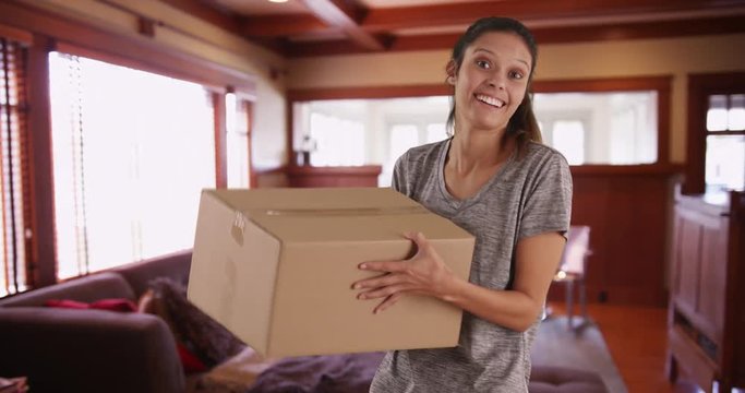 Joyful young woman in home tossing shipping box in air, Pretty brunette female holding box from Internet purchase excited to open it, 4k