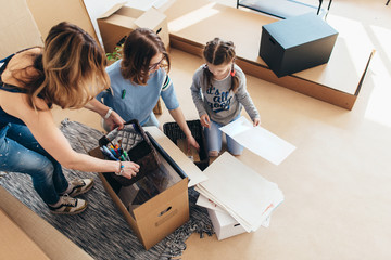Family packing boxes in new home on moving day