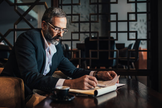 Businessman Writing in Notebook