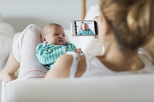 Mother taking picture of her newborn baby