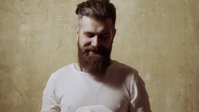 man is going to the toilet. The man is unwrapping the toilet paper