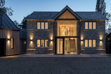 Modern glass fronted house illuminated at night.