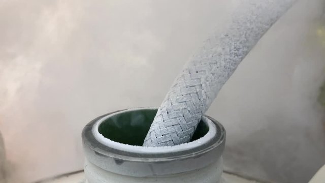 Close up of container with liquid nitrogen,Cold metal pipe smoking from transferring liquid nitrogen 
