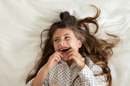Laughing child wearing black and white polka dot shirt