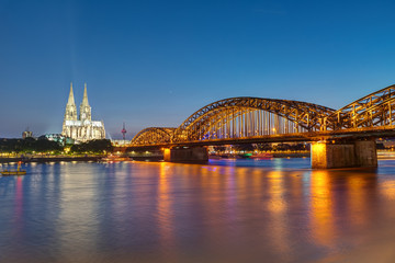 Fototapeta premium The famous Cologne Cathedral and the Hohenzollern railway bridge at night