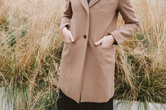 Crop image of woman with hands in a pockets of a coat