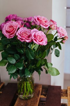Indoors shot of bouquet of pink delicate roses in glass vase