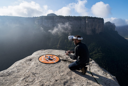 Man launching drone from the peak of mountain.