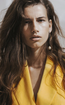 Young female /fashion model in abstract white space with yellow outfit.