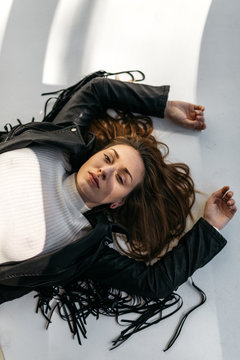 Young adult woman indoors studio with light patterns and shadows on face