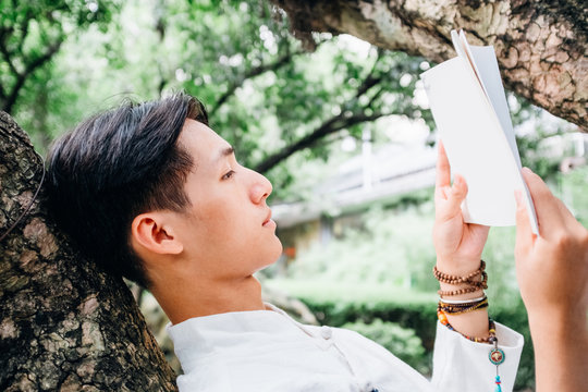 Asian man reading book in zen style traditional Chinese clothing
